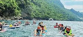 天峨红水河桨板上的人群与沿岸山景，蓝刀鱼观赏点
